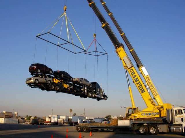 A crane lifting multiple cars