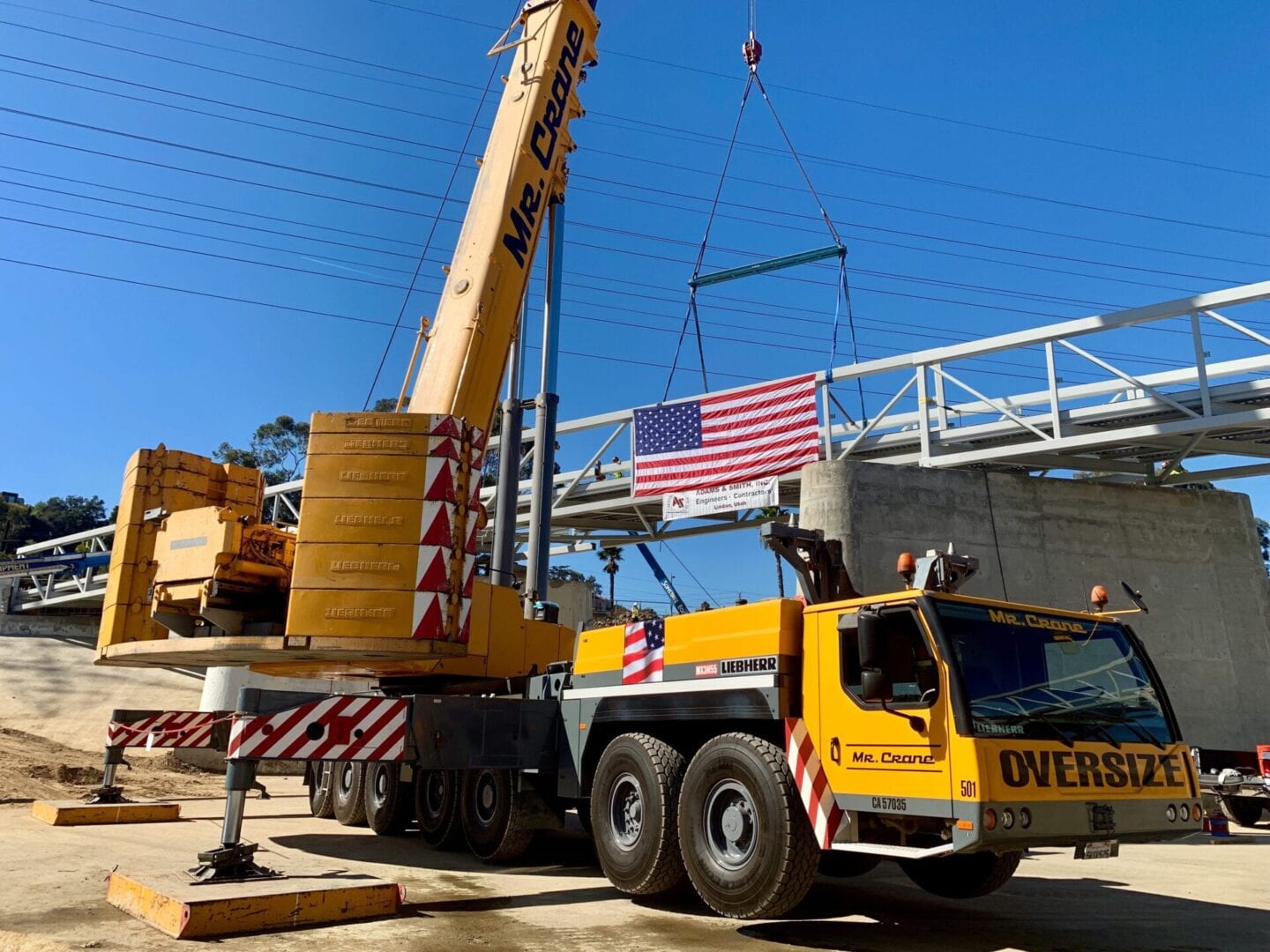 A crane lifting a bridge with an American flag
